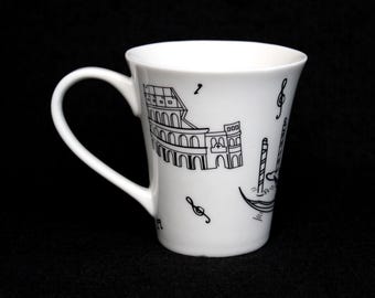 May include: White ceramic mug with a black and white illustration of the Colosseum and a gondola. The mug has a black musical note on the side.
