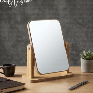 Peut inclure: Un miroir de table rectangulaire avec un cadre et un support en bois clair. Le miroir est monté sur un mécanisme pivotant permettant un réglage de l'inclinaison. La base est une pièce de bois plate et rectangulaire. La surface est réfléchissante.