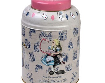 May include: A white tin with a pink lid featuring an illustration of Alice in Wonderland holding a flamingo. The tin has a blue and white pattern of playing cards and other Alice in Wonderland characters. The text on the tin reads "New English Teas English Afternoon Tea 240 Teabags".