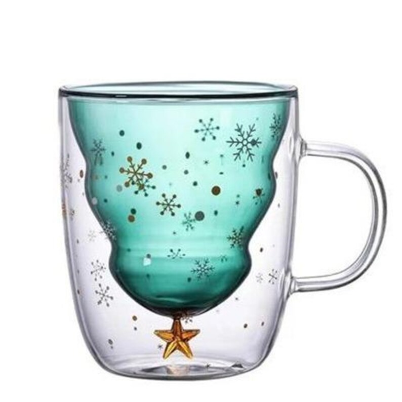 May include: Double-walled glass mug with a teal interior shaped like a Christmas tree. The teal interior is decorated with gold snowflakes and dots. A gold star is at the bottom. The outer layer is clear glass with snowflake accents.