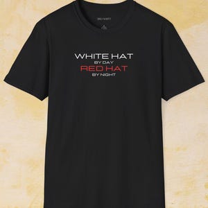 Puede incluir: Camiseta negra con el texto "WHITE HAT BY DAY RED HAT BY NIGHT" en letras blancas y rojas.