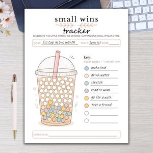 Può includere: Un foglio di tracciamento in carta intitolato small wins tracker con un'illustrazione di tè boba e cerchi vuoti da riempire. La pagina include sezioni per obiettivo, inizio, fine e una legenda con cerchi colorati per le attività.