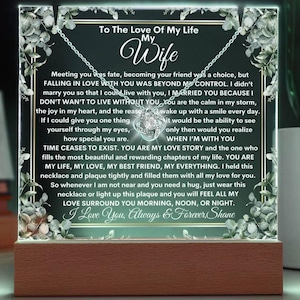 May include: A wooden plaque with a glowing light behind it. The plaque has a floral design and a message that reads "To The Love Of My Life My Wife". The message continues with a heartfelt poem about love and marriage. The plaque also features a silver necklace with a heart-shaped pendant.