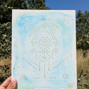 K&ouml;nnte beinhalten: Ein rechteckiger Kunstdruck mit einem hellblauen und wei&szlig;en Aquarellhintergrund und goldenen Linienzeichnungen. Das Design umfasst ein zentrales Dreieck, eine Spirale und verschiedene geometrische Symbole mit goldenen Farbspritzern.