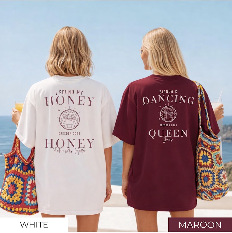 May include: Two oversized t-shirts, one white and one maroon, with text and graphic designs on the back. The white shirt says "I FOUND MY HONEY" and "HONEY" with a globe graphic. The maroon shirt says "BIANCA'S DANCING QUEEN".