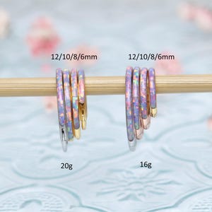 May include: Four sets of opal hoop earrings in different sizes, 6mm, 8mm, 10mm, and 12mm. The earrings are shown on a wooden dowel rod. The earrings are available in 16 gauge and 20 gauge.