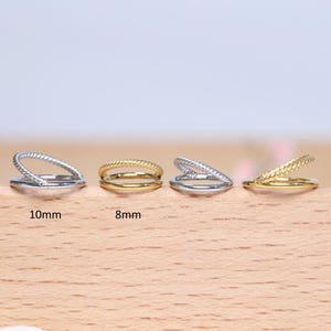 May include: Four silver and gold double hoop earrings in different sizes. The earrings are 8mm and 10mm in diameter.