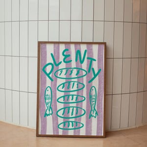 May include: A framed print with a purple and white striped background. The word "PLENTY" is written in green with a circle around it. There are five green circles with lines inside them and two green fish on either side of the circles.