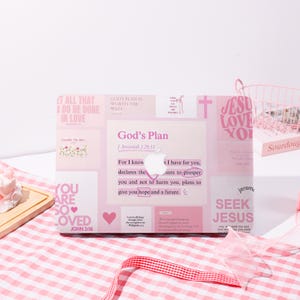 Puede incluir: Una funda rosa para portátil con varias citas y frases inspiradoras. La funda presenta textos como "God's Plan", "Jesus Love You" y "You are so loved". El diseño incluye un corazón y una cruz.
