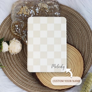 May include: A white and beige checkered notebook with the name "Melody" written on the cover. The text "CUSTOM YOUR NAME" is below the notebook.