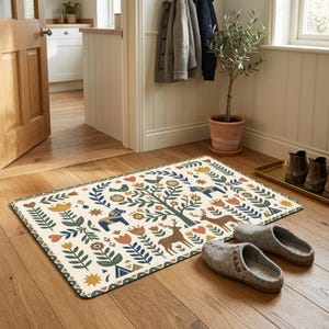 Puede incluir: Una alfombrilla rectangular con fondo crema que presenta un patrón de arte popular con ciervos marrones, caballos azules, árboles verdes y flores coloridas en tonos naranja, amarillo y azul, con un borde de color verde oscuro.