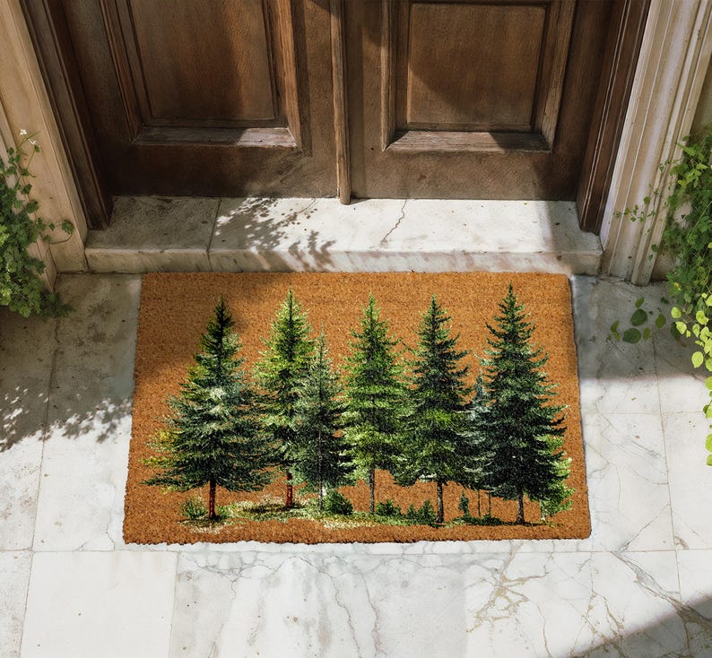 A decorative mat with a forest scene on it, placed on a tiled floor in front of a wooden door.