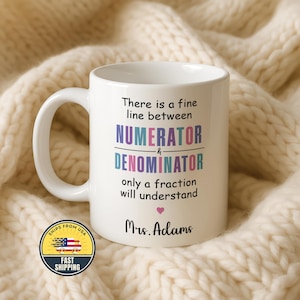 May include: White ceramic mug with a large handle, featuring the text "There is a fine line between NUMERATOR & DENOMINATOR only a fraction will understand" in colorful lettering. The mug also includes the name "Mrs. Adams" and a small heart.