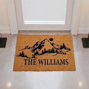 A door mat with a mountain landscape and the text "THE WILLIAMS" printed on it.