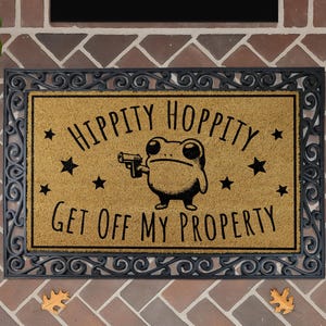 a door mat with a cartoon frog holding a gun and the text "Hippity Hoppy Get off my Property" printed on it.