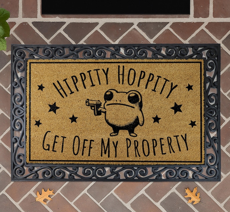 a door mat with a cartoon frog holding a gun and the text "Hippity Hoppy Get off my Property" printed on it.