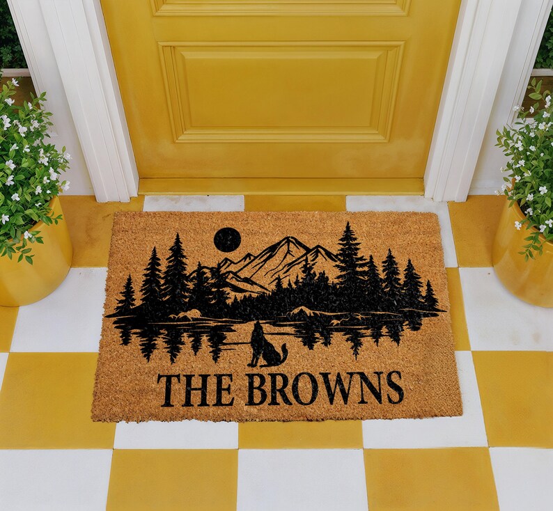 A yellow door with a mat featuring a mountain landscape and a wolf silhouette, with the text "THE BROWNS" printed on it.