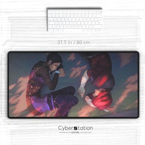 May include: A large mouse pad featuring a digital illustration of two women in colorful clothing, lying on a cloudy background. The mouse pad is 31.5 inches wide and 15.5 inches tall. The text "Cyberstation Central" is printed in the bottom center of the mouse pad.