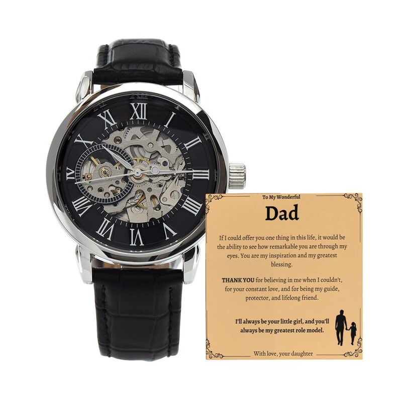 May include: A black and silver wristwatch with a skeleton dial and Roman numeral hour markers. The watch has a black leather band and is displayed with a card that reads "To My Wonderful Dad".
