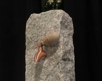 Stone Liquor and wine dispenser has stainless steel spigot w/ copper patina