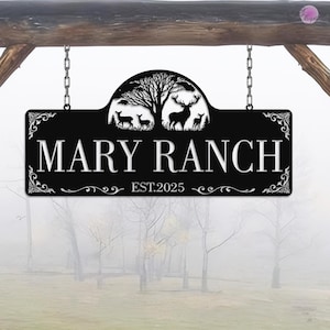 May include: Black metal sign with the words "MARY RANCH" in white, with a decorative tree and deer silhouette. The sign is suspended by chains and includes the text "EST.2025".