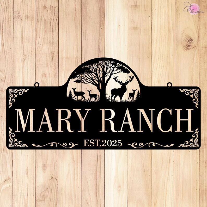 May include: Black metal sign with the words "MARY RANCH" and "EST.2025" in a decorative font. The sign features a silhouette of a tree, deer, and a decorative border. The sign has two holes for hanging.