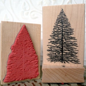 Può includere: Due timbri in legno con un design ad albero di Natale. Un timbro ha una forma di albero rossa e strutturata, l'altro mostra un'illustrazione dettagliata di un albero nero. Ideali per l'artigianato e i progetti festivi.