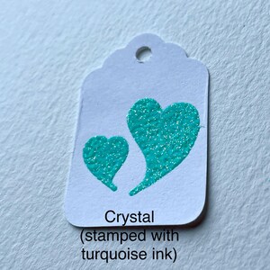 May include: White tag with a turquoise heart design. The tag reads "Crystal (stamped with turquoise ink)"