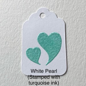 May include: White Pearl gift tag with two turquoise hearts stamped on it. The text on the tag reads "White Pearl (Stamped with turquoise ink)"