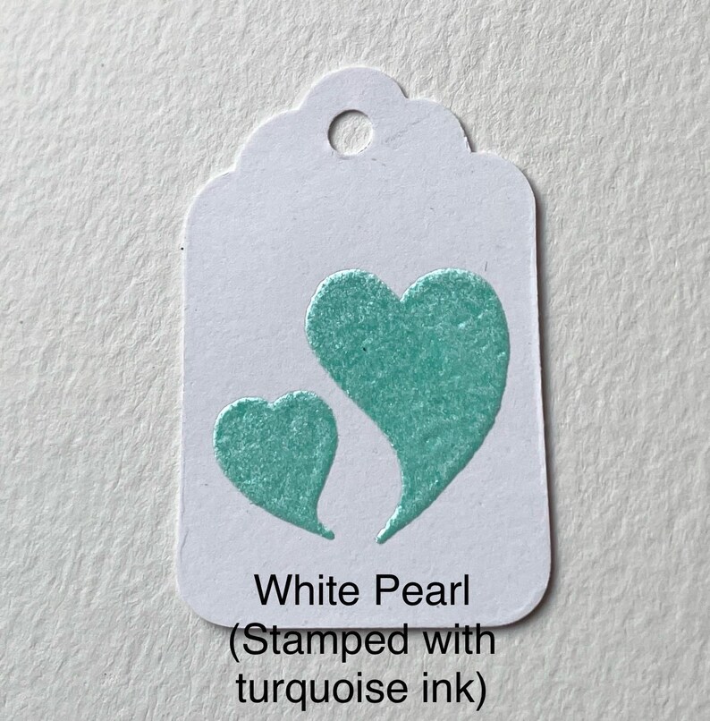 May include: White Pearl gift tag with two turquoise hearts stamped on it. The text on the tag reads "White Pearl (Stamped with turquoise ink)"