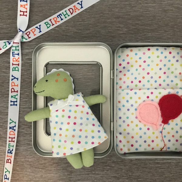 Happy Birthday Dino! Teensy Tinsies miniature plush dinosaur in a clear window tin. Nap time tuck-in pocket blanket bed & removable dress.