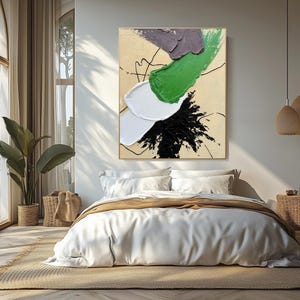 Pode incluir: Pintura abstrata com pinceladas brancas, verdes, pretas e cinzas sobre um fundo bege. A pintura est&aacute; pendurada em uma parede de um quarto com uma cama branca e uma manta marrom.