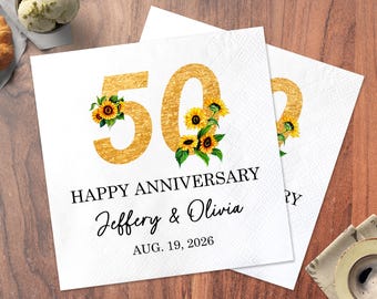 May include: Two white paper napkins with a gold "50" and sunflower accents. The napkins read "Happy Anniversary" and include the names "Jeffery & Olivia" and the date "Aug. 19, 2026".