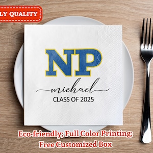 Puede incluir: Servilleta cuadrada blanca con las letras "NP" azules y doradas, el nombre "michael" y "CLASS OF 2025". La servilleta está sobre un plato blanco, con un tenedor plateado a la derecha. El texto "3-PLY QUALITY" está en un recuadro rojo.