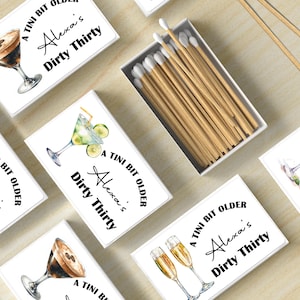 May include: A set of six matchboxes with a white background and black text. Each matchbox features a different cocktail illustration and the text "A Tini Bit Older Alexa's Dirty Thirty".