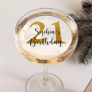 以下が含まれることがあります： 白いステッカーに金色の21と「Sophia's Birthday」の文字が書かれたシャンパングラス