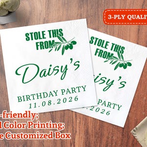 Puede incluir: Dos servilletas de papel blancas con texto verde que dice "STOLE THIS FROM Daisy's BIRTHDAY PARTY 11.08.2026". Las servilletas tienen un diseño de rama de olivo. Las palabras "3-PLY QUALITY" están en un rectángulo rojo.