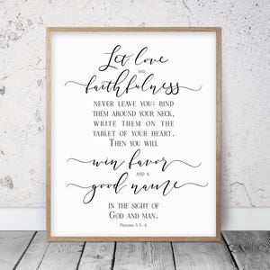 Peut inclure: Une impression encadrée avec les mots "Let love and faithfulness" en écriture élégante. Le texte continue avec une citation de Proverbes 3:3-4, à l'encre noire sur fond blanc, dans un cadre en bois brun clair.