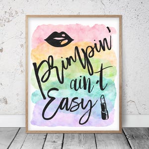 May include: A framed print with the text "Pimpin' ain't Easy" in black script over a watercolor background of pink, yellow, green, and blue. The image includes a black lip graphic and a lipstick illustration.