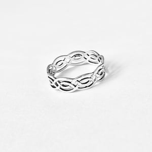 May include: A silver ring with a Celtic knot design. The ring is simple and elegant.