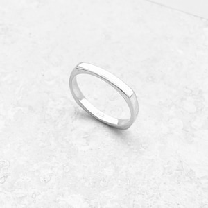 May include: A simple silver band ring with a square shape.