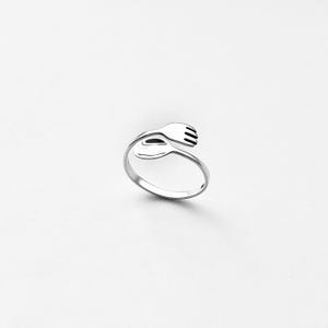 May include: A silver ring shaped like a fork and spoon intertwined.