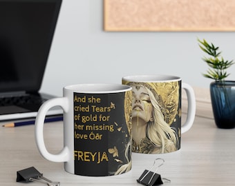 May include: White ceramic mug with a black background and gold accents. The mug features a woman with gold tears and the text "And she cried Tears of gold for her missing love Óðr FREYJA".