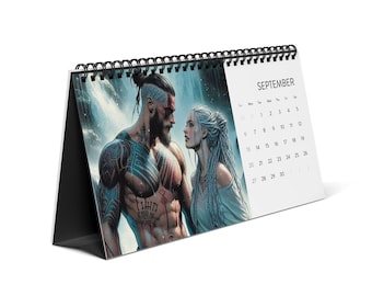 May include: A desk calendar featuring a digitally illustrated image of a man and woman with a waterfall backdrop. The calendar is open to September, with the month's name and dates visible. The calendar has a black spiral binding and a black stand.