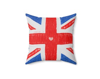 May include: Square pillow featuring a hand-drawn Union Jack design. The pillow has a white background with red, white, and blue accents. A small white heart is in the center of the red cross.