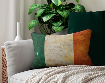 May include: Rectangular pillow featuring the Irish flag design in green, white, and orange. The pillow has a distressed, textured appearance. It rests on a gray sofa with other green pillows and a cream-colored throw blanket.