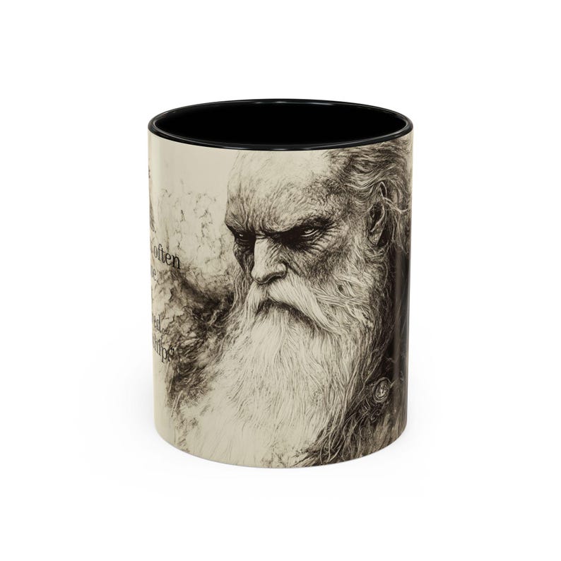 May include: A ceramic mug with a black interior, featuring a sepia-toned illustration of an elderly man with a long white beard. The mug has text on the side.