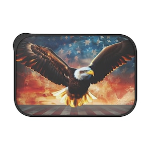 May include: A rectangular case featuring a majestic bald eagle with outstretched wings against a backdrop of the American flag. The eagle has brown and white feathers, a yellow beak, and is set against a red, white, and blue background.