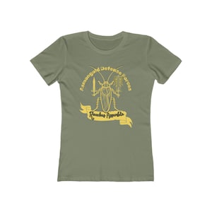 Può includere: T-shirt verde oliva con grafica gialla di uno scarafaggio con una spada e uno striscione con la scritta "Roaches Assemble". Il testo "Asmongold Defense Forces" è arcuato sopra l'illustrazione dell'insetto.