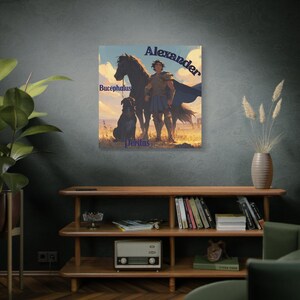 May include: A canvas print featuring an illustration of Alexander the Great with his horse Bucephalus and dog Peritas. The artwork depicts Alexander in armor and a blue cape, standing in a sunny landscape. The names "Alexander", "Bucephalus", and "Peritas" are written in blue.
